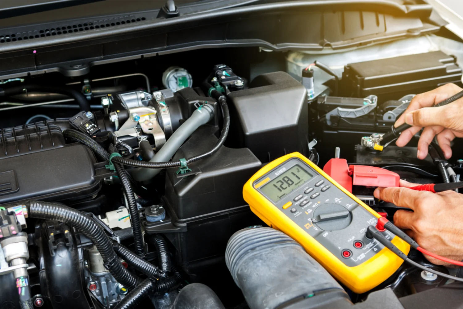 Mechanic using a multimeter to diagnose auto electrical faults