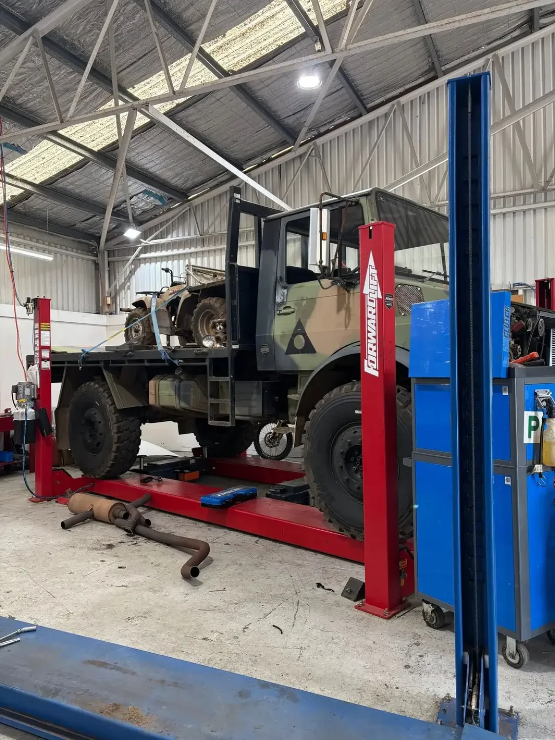 Heavy diesel vehicle on a hoist inside the Launceston Motorworks workshop