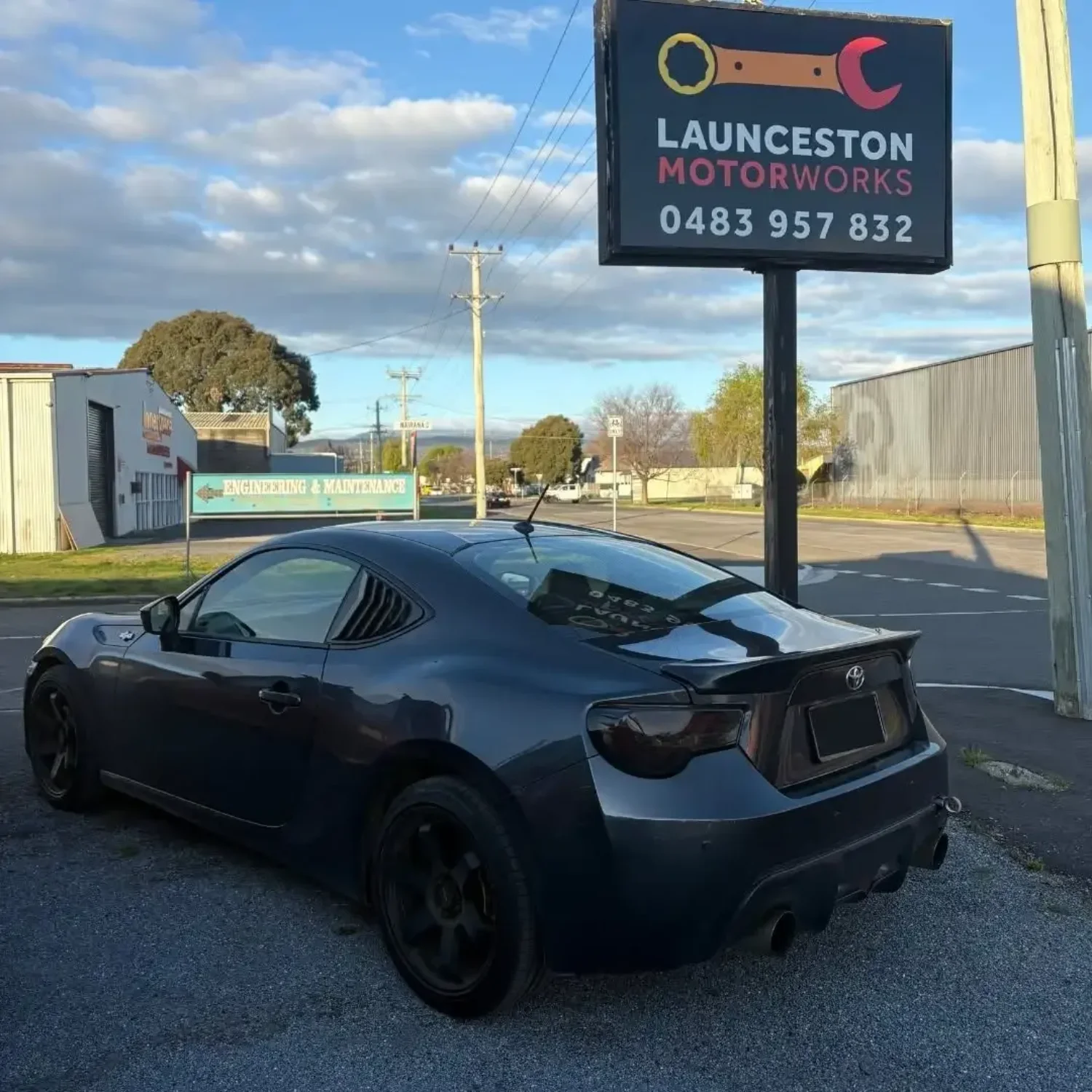 Toyota 86 parked next to the Launceston Motorworks street sign in Invermay