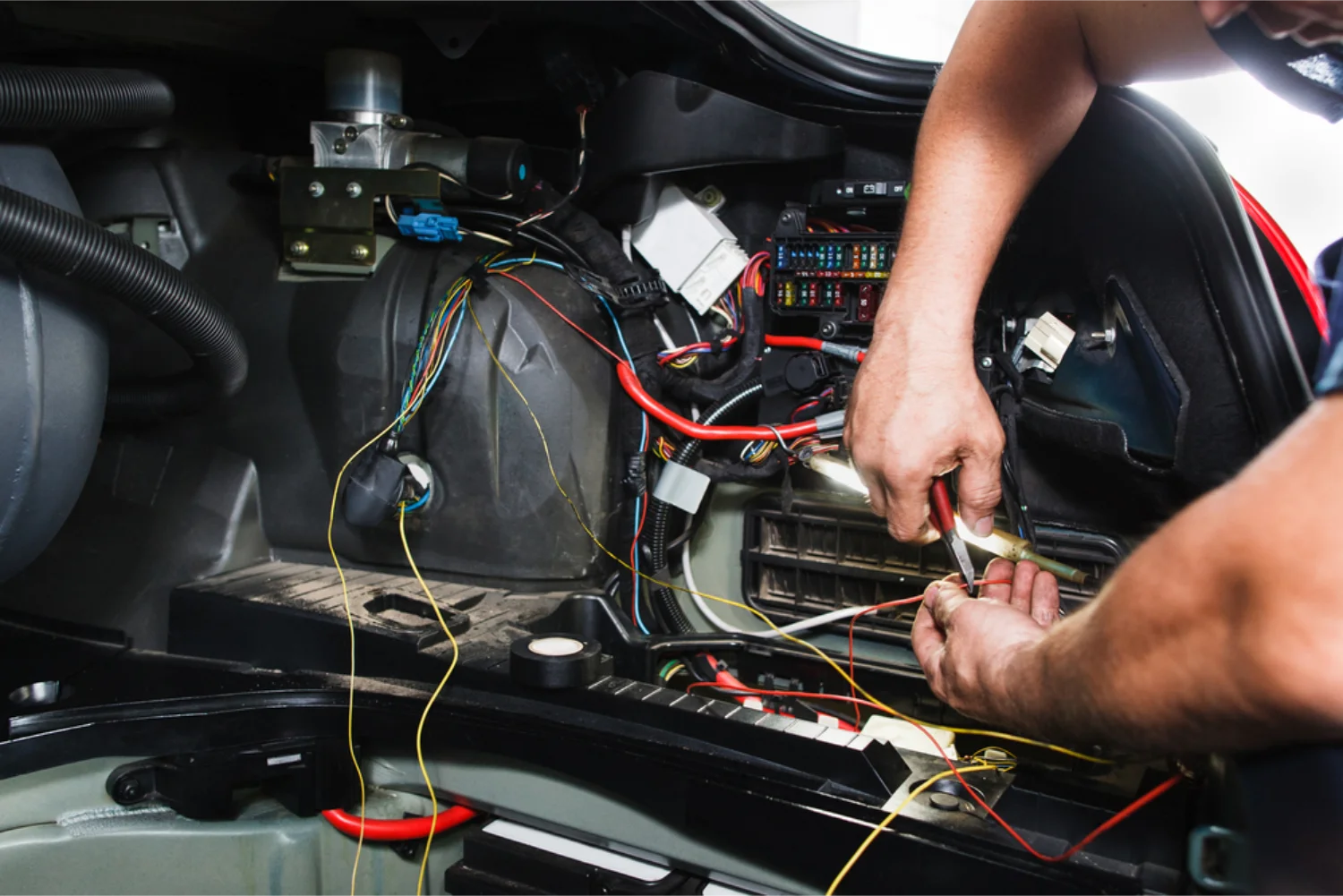 Auto electrician tracing wiring loom faults in a vehicle dashboard