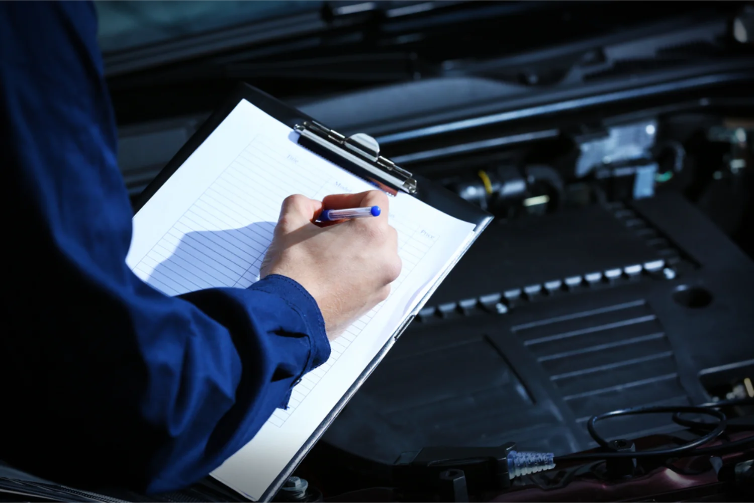 Mechanic completing a logbook service checklist
